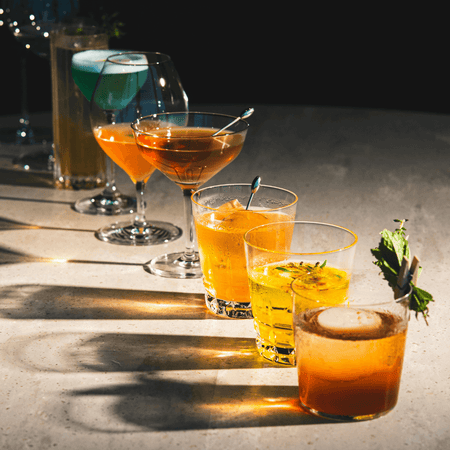 Cadeaux pour les amateurs de vins et cocktails : collection de cocktails élégants en verre sur une table.