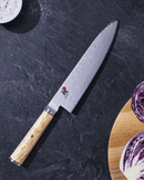 Couteau GYUTOH Miyabi 5000MCD 24 cm sur le plan de travail
