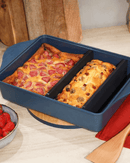 Plat ajustable Cookut en teinte myrtille, avec séparateur breveté pour des recettes variées.

