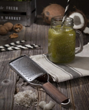 Râpe à gros grains Microplane Master avec manche en bois et boisson verte sur table en bois rustique.