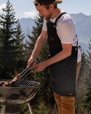  Tablier Alaskan Maker N°515 noir en toile waxée robuste et déperlante.