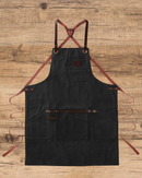 Tablier Alaskan Maker N°547 noir en toile waxée avec finitions cuir.