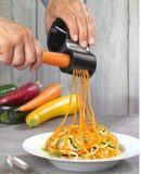 Taille légumes spirale Microplane avec carotte et spaghetti de légumes sur une assiette.