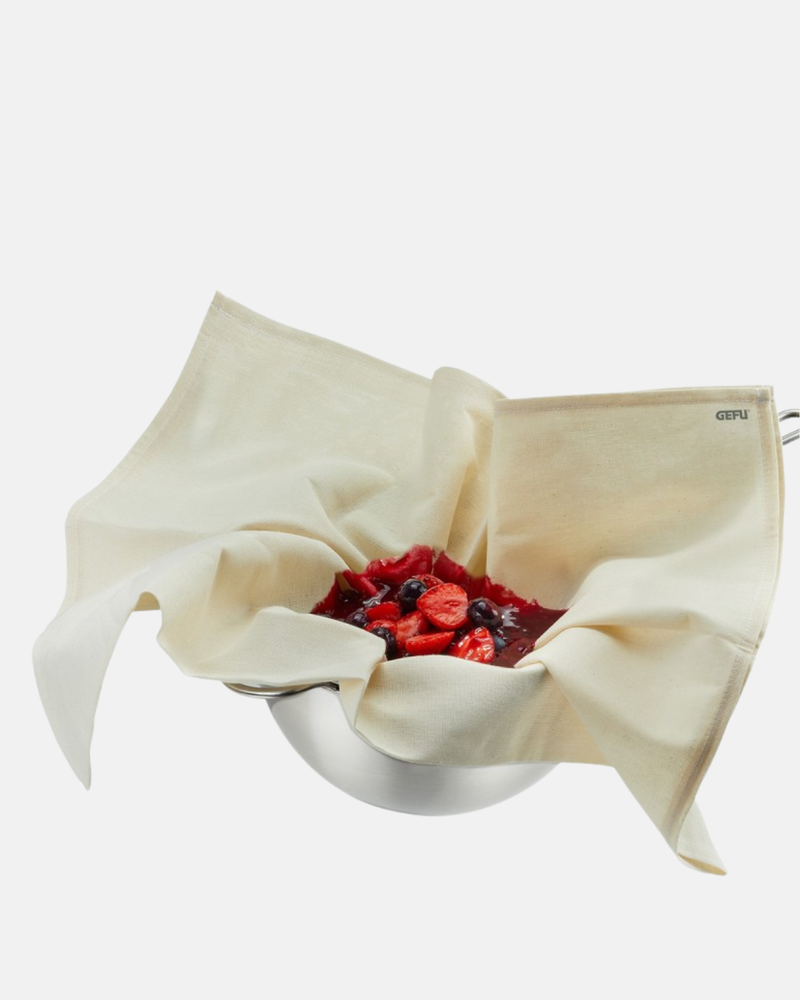 Tissu de filtration GEFU Paselo utilisé pour presser des fruits dans un bol en acier inoxydable.
