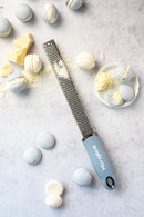 Zesteur Premium Classic Microplane on a countertop with blue macarons and chocolate pieces.