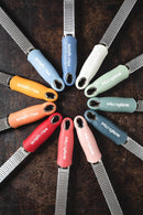 Zesteur Premium Classic Microplane in various colors arranged in a circle on a rustic background.